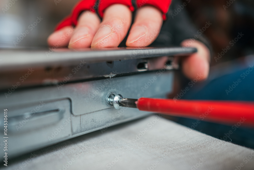Technician carefully repairs a laptop motherboard in a workshop, showcasing expertise in electronics maintenance