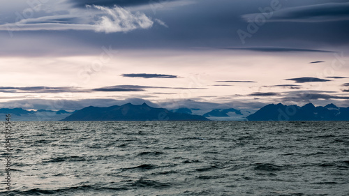 Stunning view of Svalbard\'s remote coastline under dramatic cloudy skies at dusk photo