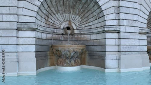 Fountain in Louise Michel square (place) on top of Montmartre hill next to the Basilica of Sacre Coeur. Running water stream, fountain. Paris, France photo