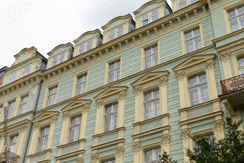 A very large structure that has numerous windows and an inviting balcony where people can enjoy the view of the surroundings