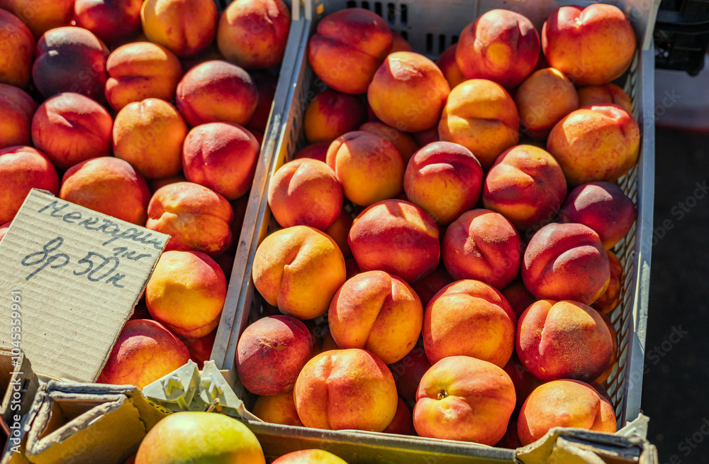 Farm fresh peaches on display in the morning sun at a local farmers market. Farm fresh peaches on display in the morning sun at a local farmers market.