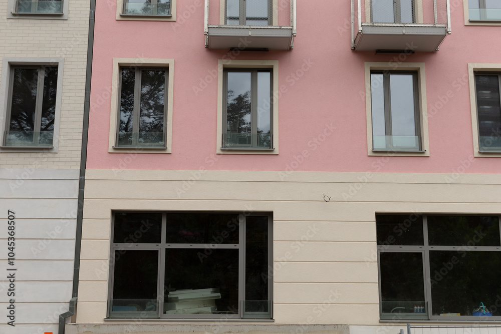 Obraz premium There is a pink building that features an abundance of windows and numerous balconies, making it a striking sight in the neighborhood