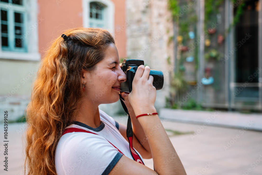 Young woman taking pictures while sightseeing in the city