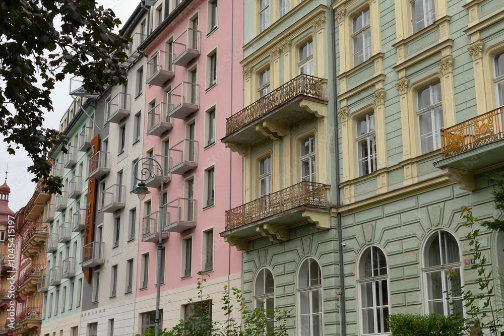 Naklejka premium A picturesque row of buildings featuring balconies and fire escapes located in a bustling city environment, showcasing urban architecture