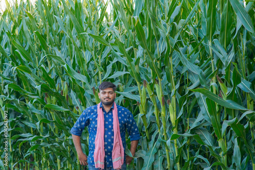 young Indian farmer standing in maize farm photo