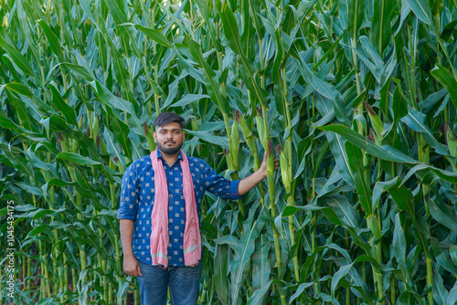 young Indian farmer standing in maize farm photo