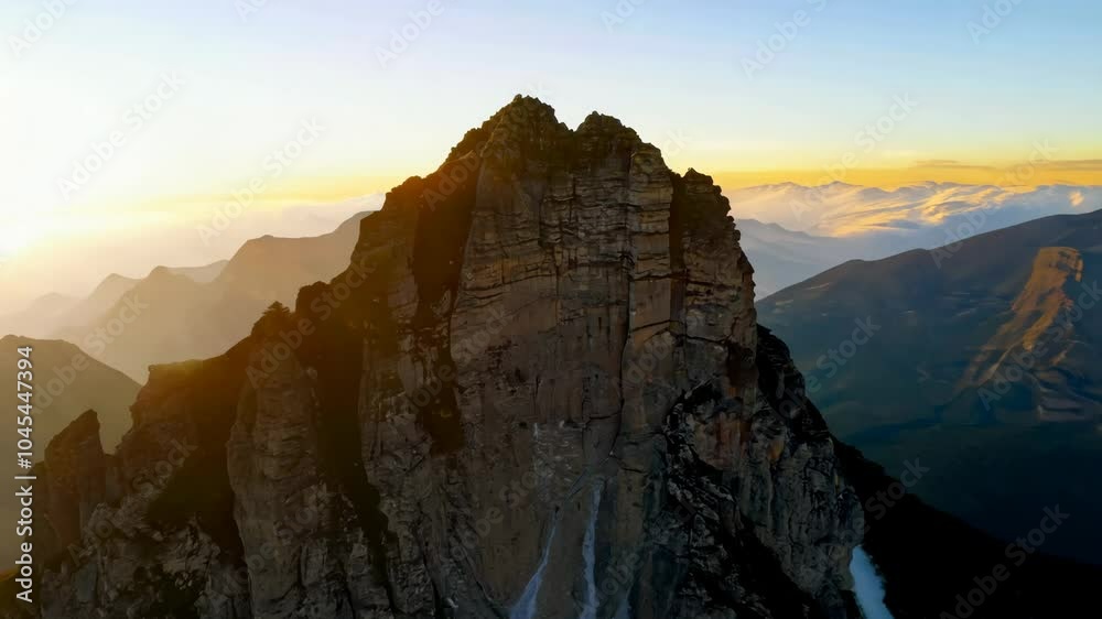 A rocky mountain top bathed in soft evening light, with a serene sky in the background A rocky mountain top bathed in soft evening light, with a serene sky in the background