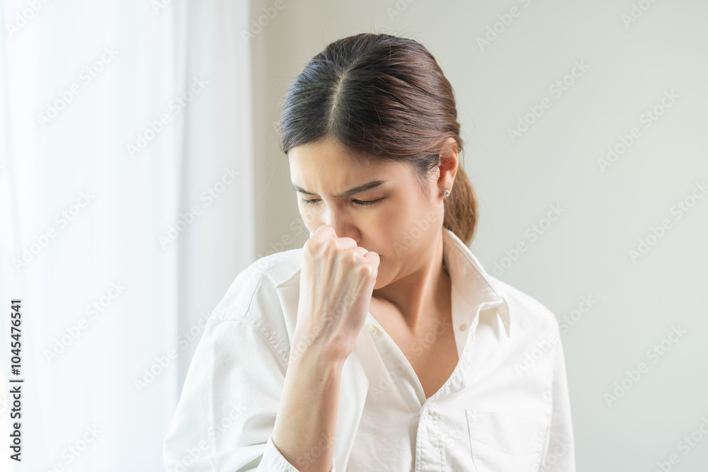Bad smell nose concept asian young housewife woman having smelling clothes her shirt collar, sniff smelly dirty stinky musty, look disgusting from clothes after washed, laundry out of machine at home. Bad smell nose concept asian young housewife woman having smelling clothes her shirt collar, sniff smelly dirty stinky musty, look disgusting from clothes after washed, laundry out of machine at home.