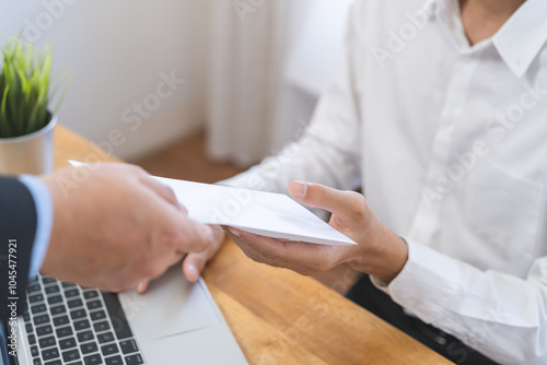 Good job Asian manager business man giving financial reward in an envelope, business letter extra salary to company employee, male worker office hand received premium bonus, getting cheque from boss. photo