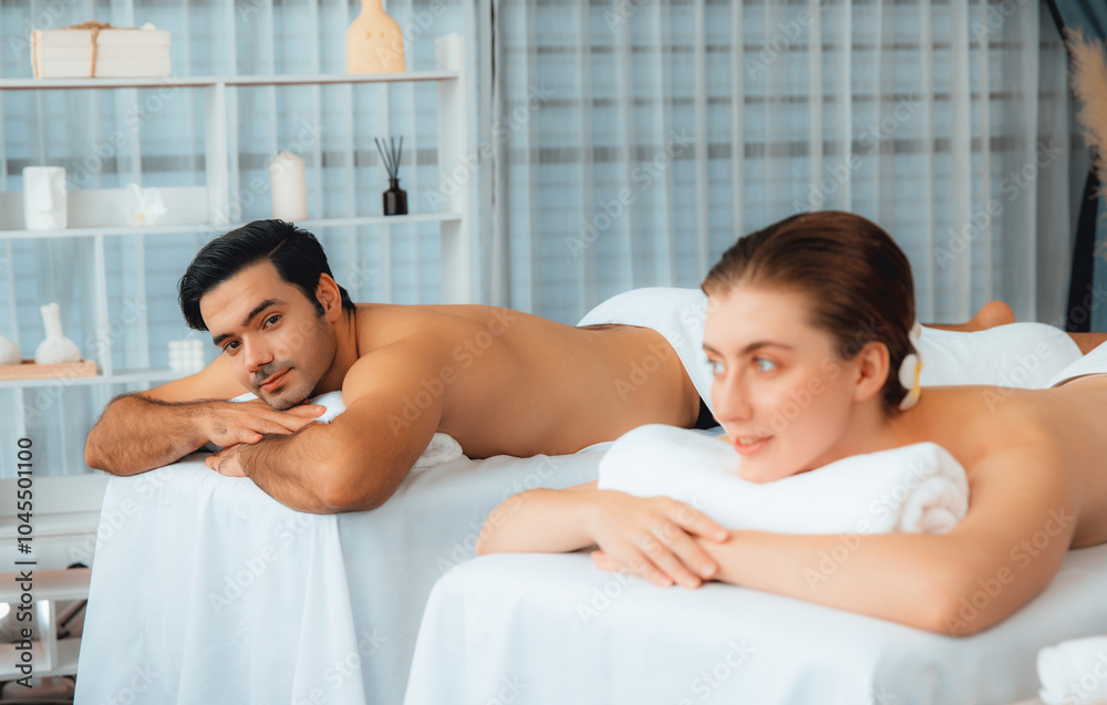 Caucasian couple customer enjoying relaxing anti-stress spa massage and pampering with beauty skin recreation leisure in day light ambient salon spa at luxury resort or hotel. Quiescent Caucasian couple customer enjoying relaxing anti-stress spa massage and pampering with beauty skin recreation leisure in day light ambient salon spa at luxury resort or hotel. Quiescent