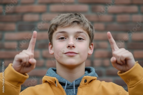 A young boy making a positive gesture with his hands, suitable for use in illustrations about optimism and joy photo