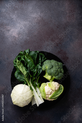 Assortment of fresh organic homegrown cabbage (broccoli, white cabbage, cauliflower, bok choy leaves)