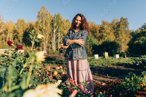 Smiling woman with folded arms , finding fulfillment and joy in her eco-friendly homestead Autumn day of contentment, Woman enjoying her garden and sustainable lifestyle photo