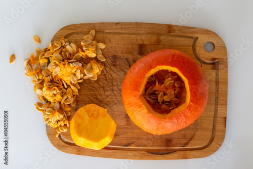 Halloween pumpkin gutting before carving Jack-o'-lantern. Guts and seeds inside a pumpkin being removed with knife, through cut off top lid.