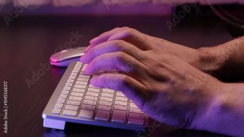 Mens hands press the keys on a keyboard glowing with neon lights A modern and futuristic scene that emphasizes technology and the workflow