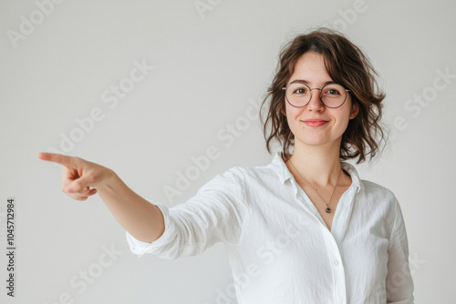 Woman in glasses pointing excitedly at a colorful butterfly fluttering by.