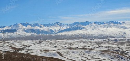 Panoramic view of the snow-capped mountains of the Zailiyskiy Alatau from the Ushkonyr plateau (Kazakhstan) in autumn photo