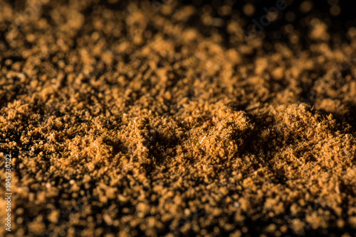 Close-up of fine brown powder scattered across a dark surface.