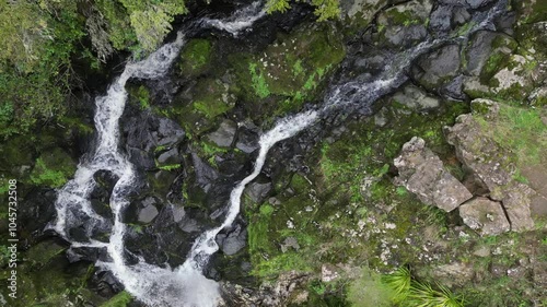 Aerial footage of the Paranui Falls cascading on rocks during daytime in Whareora, New Zealand photo