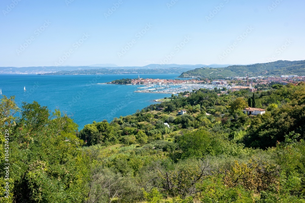 Picturesque coastal town nestled along a scenic peninsula with blue sky on the horizon Picturesque coastal town nestled along a scenic peninsula with blue sky on the horizon