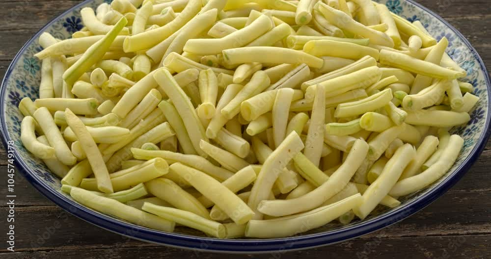 Freshly harvested, trimmed, and sliced yellow string beans in a bowl. Table spin. Freshly harvested, trimmed, and sliced yellow string beans in a bowl. Table spin.