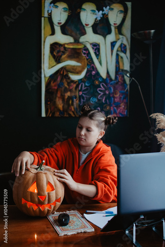 Wallpaper Mural Caucasian happy girl orange color cloths near carved Halloween pumpkin studying online laptop Torontodigital.ca