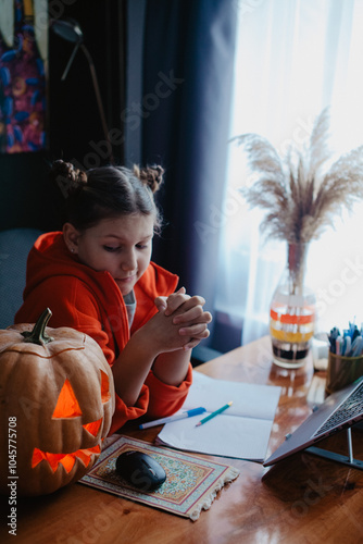 Wallpaper Mural Caucasian happy girl orange color cloths near carved Halloween pumpkin studying online laptop Torontodigital.ca