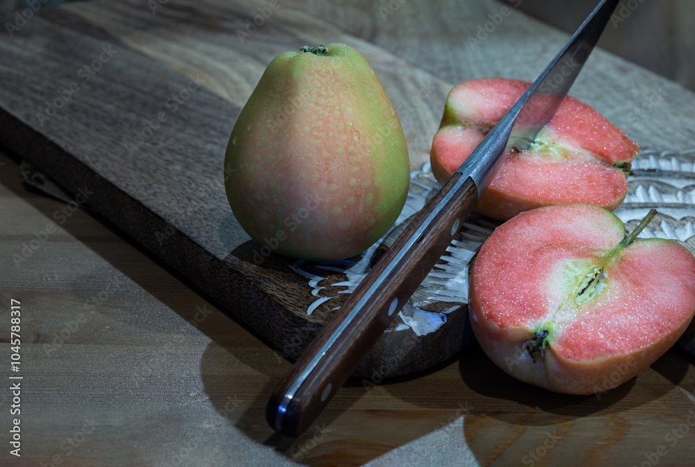 Fresh kissabel apple fruit and Cut the apple in each half with knife on wooden cutting board. Naturally pink flesh kissabel apple with a unique zesty taste, Space for text, Selective Focus.