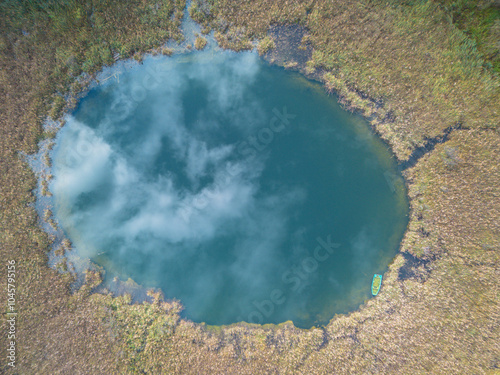 reflet du ciel et des nuages dans un lac arrondi de tourbière. Vue aérienne d'un lac à Virieu-le-Grand dans l'Ain en France photo