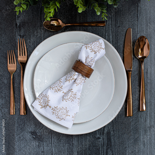 formal place setting on grey table with copper silverware