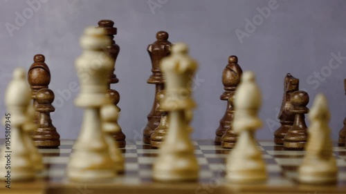 Black figures in focus. Chess board plain wooden figures. Match is ready to start. Camera dolly