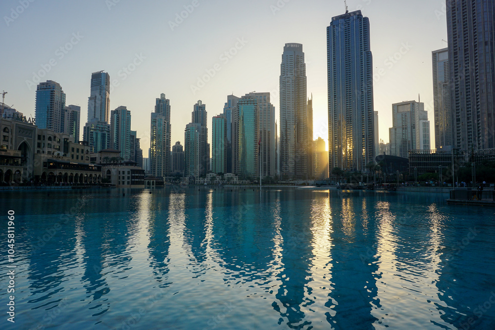 Fototapeta premium Dubai's modern city skyscraper skyline at sunset - business center of United Arab Emirates reflecting in the water