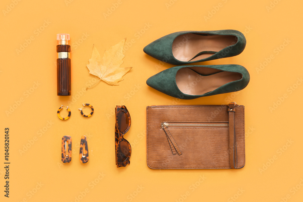 Stylish female bag with shoes, accessories and autumn leaf on orange background Stylish female bag with shoes, accessories and autumn leaf on orange background