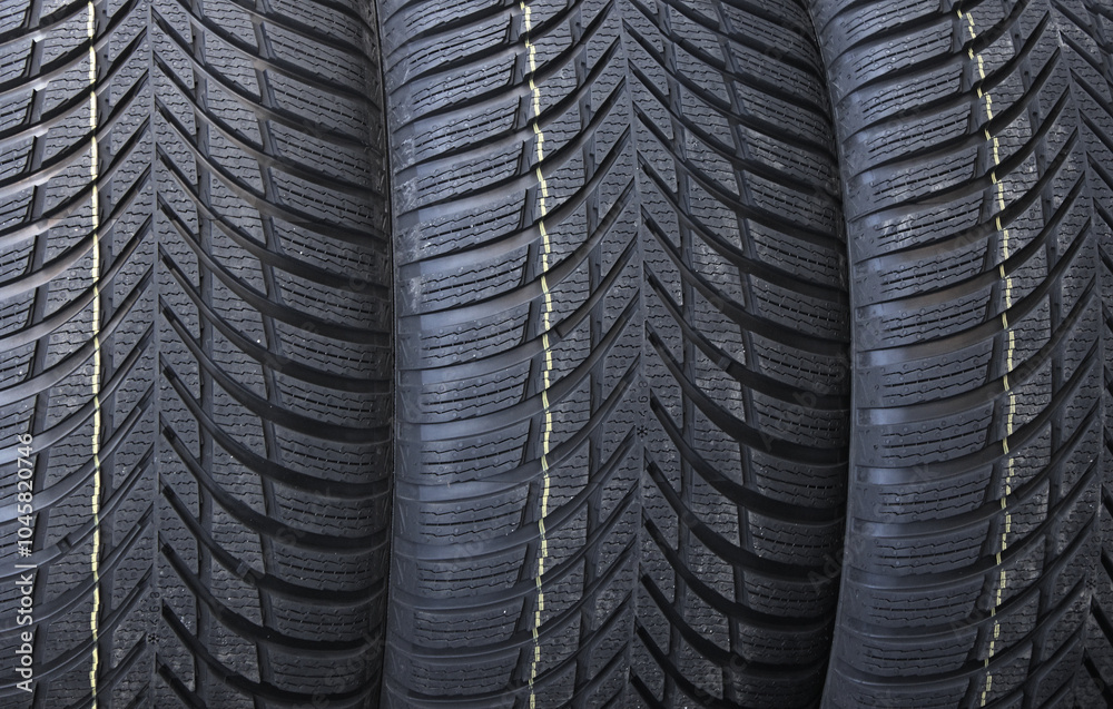 Fototapeta premium Identical Tread Pattern Design Of Non Studded Winter Tyres. New Car Tyres Texture Stock Photo For Background 