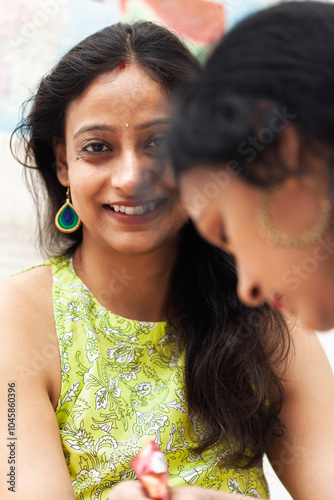 A woman is preparing for the Karwa Chauth festival by getting beautiful mehendi applied to her hands. photo