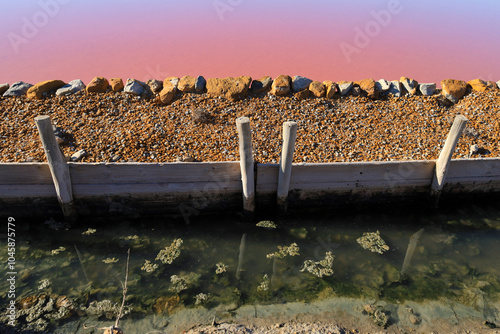 Retaining dikes in the pink lagoon of the saltworks of Santa Pola town, Spain photo