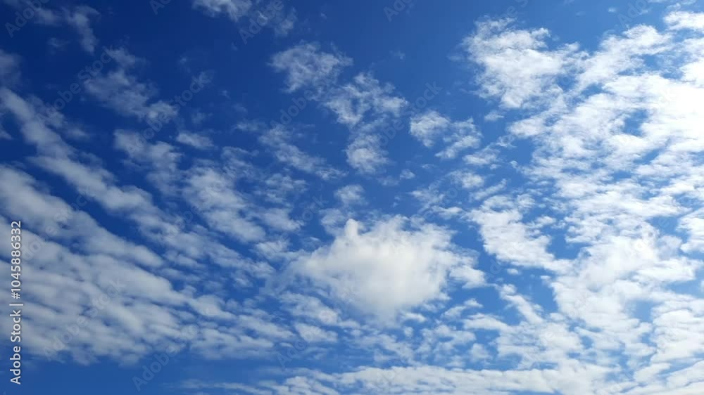 White clouds are rapidly floating across the blue sky. Against the background of a blue sky, clouds are moved by the wind White clouds are rapidly floating across the blue sky. Against the background of a blue sky, clouds are moved by the wind