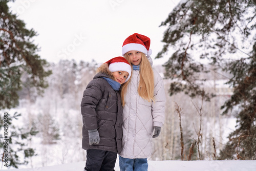 Children in festive Santa hats are joyfully enjoying a beautiful snowy winter wonderland