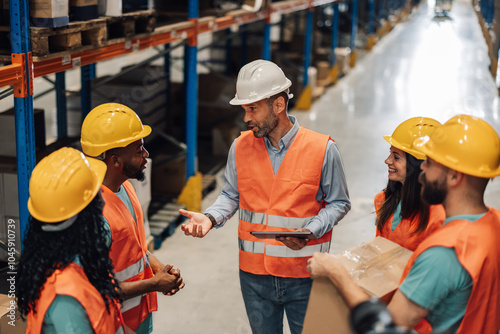 Photography Warehouse manager explaining logistics to workers holding tablet