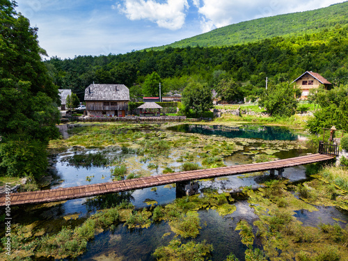 Aerial image of Wonderful Majerovo Vrilo wooden houses and Gacka river source in the village of Sinac, Croatia photo