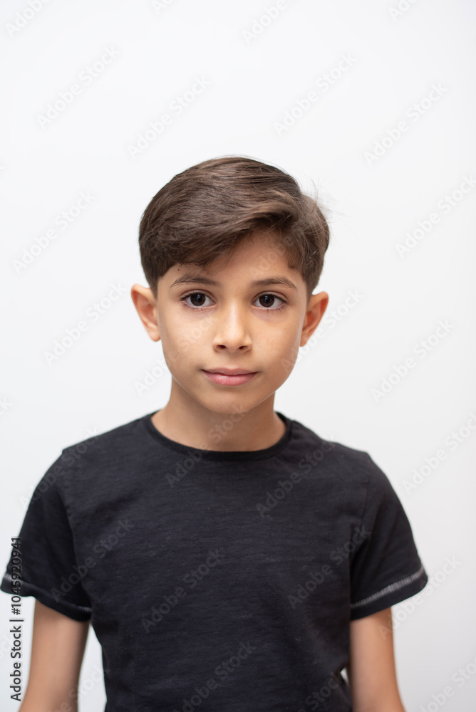 8-year-old boy looking at the camera in a simple and natural studio portrait with a white background 8-year-old boy looking at the camera in a simple and natural studio portrait with a white background
