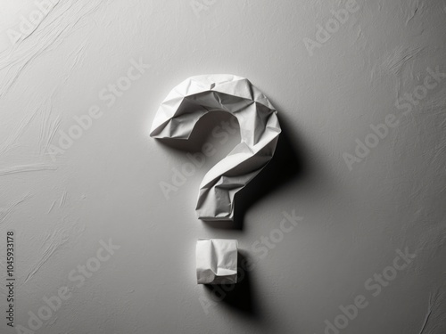 crumpled paper question mark on a gray background. photo