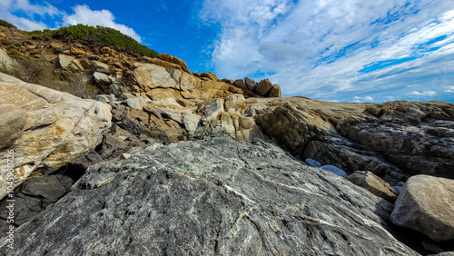 An exciting view of the granite mountains of light yellow and black colors in one of the Mediterranean island. A wide angle photo.