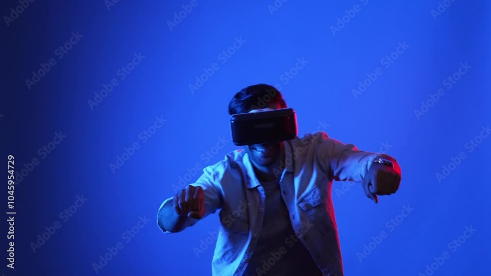 Smart gamer playing racing game while making driving motorcycle movement. Male model with casual cloth wearing virtual reality goggles and entering metadata or virtual world. Technology. Apparatus. Smart gamer playing racing game while making driving motorcycle movement. Male model with casual cloth wearing virtual reality goggles and entering metadata or virtual world. Technology. Apparatus.