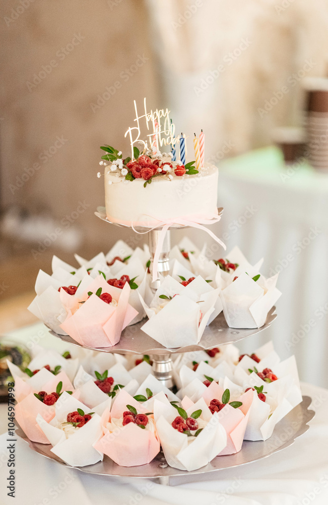 Beautiful birthday cake with cupcakes with colorful birthday candles and raspberries. Holiday cake. Beautiful birthday cake with cupcakes with colorful birthday candles and raspberries. Holiday cake.
