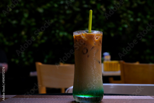 Closeup glass of coffee cocktail decorated with mint at bright bar counter background. Stir Ice Coffee with mint syrup in glass. Coffee with mint photo