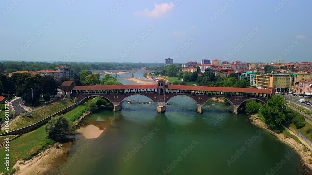 Drone view of the Ticino River and the covered bridge Ponte Coperto, which is used by vehicles and pedestrians. Arched structure. Clear transparent water. Motorboat. Italy. Pavia Italy 20.04.2025