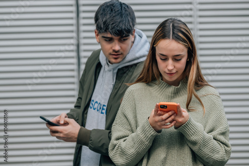 Fotografie couple spying and looking at mobile phone