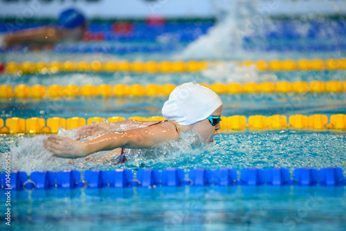 Swimmer girl swims butterfly swimming style in the pool