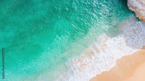 An aerial perspective showcasing crystal clear turquoise ocean waves mingling gracefully with the soft, sandy beach, creating a breathtaking natural contrast.